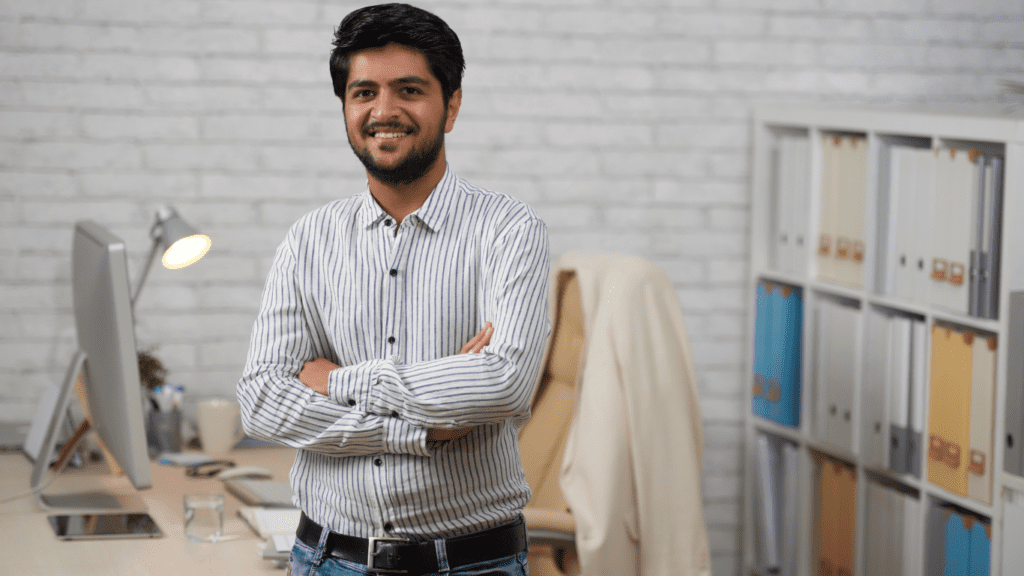 Man standing beside's his workdesk.